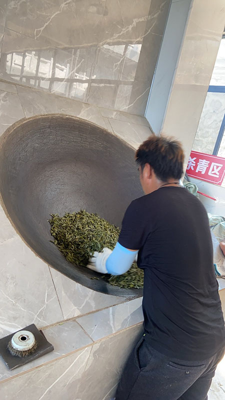 Một nghệ nhân đang sao trà bằng tay